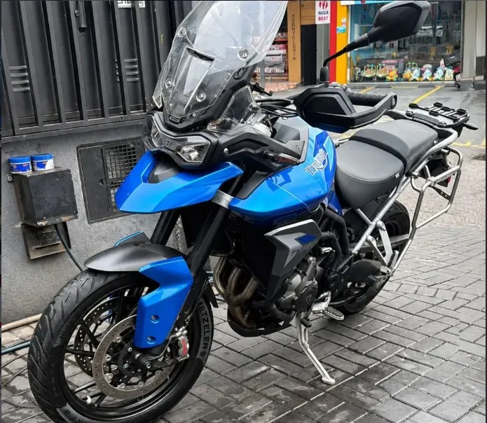 Motocicleta azul de trail estacionada na calçada, foto da publicação do cliente Gu Insolentes